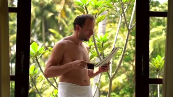 Hombre leyendo el periódico y tomando café en la terraza — Vídeos de Stock