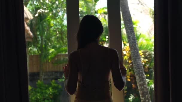 Жінка відкриває двері в сад і розтягується — стокове відео