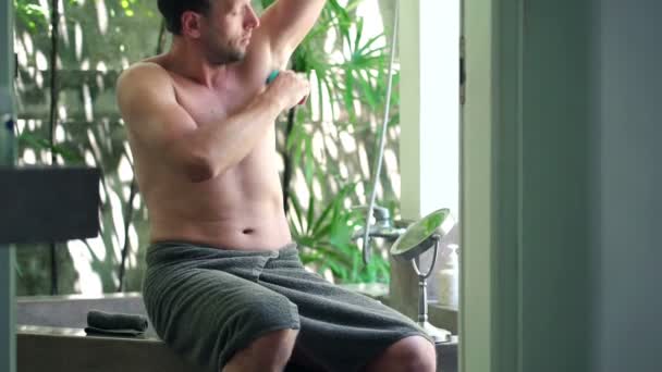 Man applying antiperspirant after shower on his armpit — Stockvideo