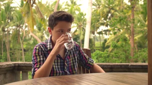 Agua potable adolescente, pensando y relajándose en la terraza — Vídeo de stock