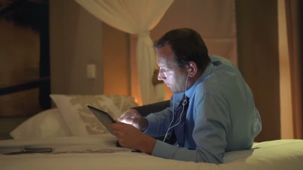 Empresario viendo película en tableta en la cama — Vídeos de Stock