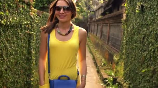 Woman walking along path with plants — Stock Video