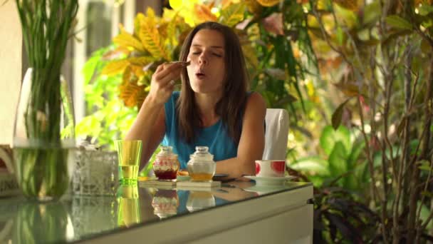 Kvinnan äter frukost av dinning tabell — Stockvideo
