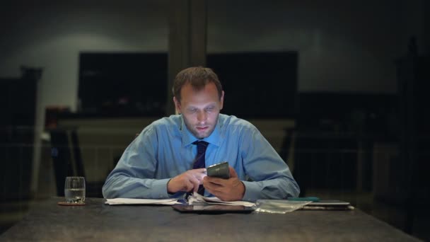 Uomo d'affari con smartphone, prendere appunti nei documenti — Video Stock