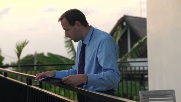 Homme d'affaires lisant des documents sur la terrasse — Video