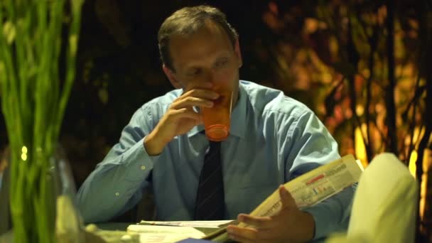 Geschäftsmann liest Zeitung und trinkt Wasser — Stockvideo