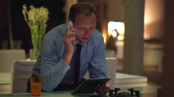 Geschäftsmann mit Handy und Tablet-Computer in Küche — Stockvideo