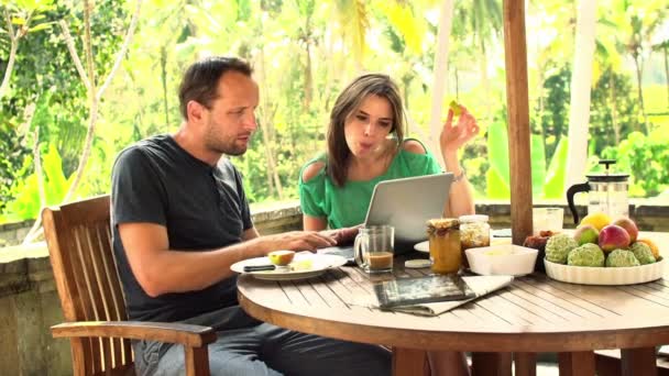 Couple talking and using laptop on terrace — Stock Video