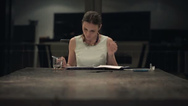 Mujer de negocios haciendo notas en documentos en la oficina — Vídeos de Stock