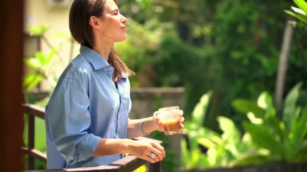 Zamyšlená žena pije kávu na terase — Stock video
