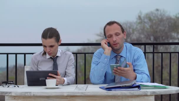 Coppia business con cellulare, smartphone e tablet al lavoro — Video Stock