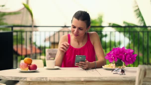Γυναίκα αποστολή sms στο smartphone στη βεράντα — Αρχείο Βίντεο