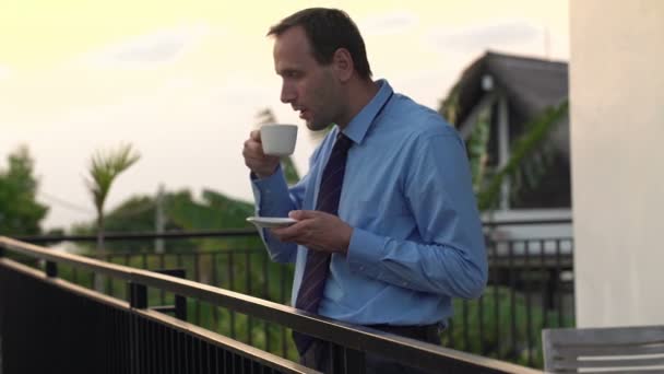 Geschäftsmann trinkt Kaffee auf der Terrasse — Stockvideo