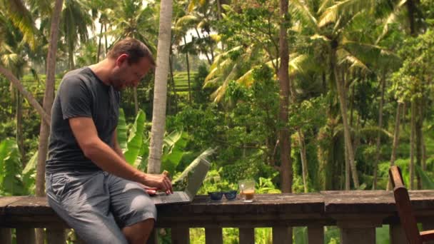 Mann mit Laptop macht Kaffeepause auf Terrasse — Stockvideo