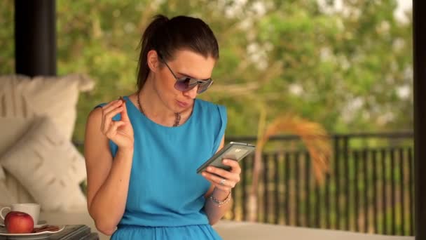 Mujer usando smartphone y comer galletas — Vídeo de stock