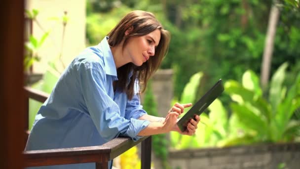 Woman with tablet computer on terrace — Stock Video