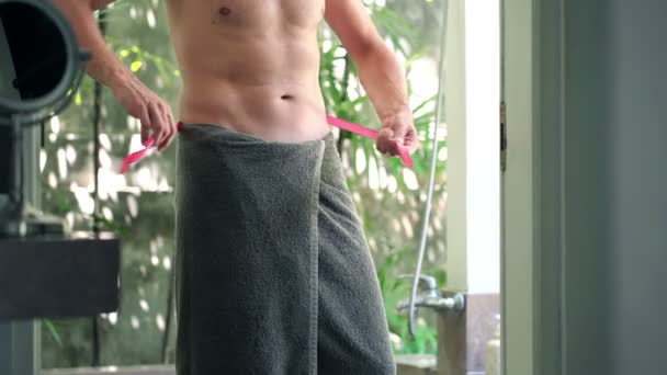 Muž měřící pás v koupelně — Stock video