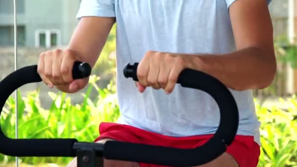 Hombre guapo haciendo ejercicio en la máquina en el gimnasio — Vídeos de Stock