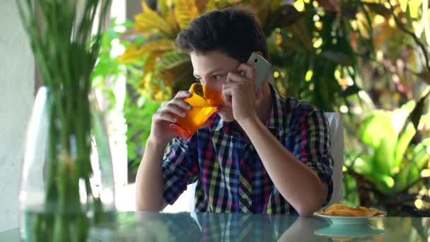 Teenager talking on cellphone and drinking water — Stock Video