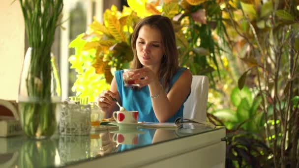 Mujer leyendo revista durante el desayuno — Vídeo de stock