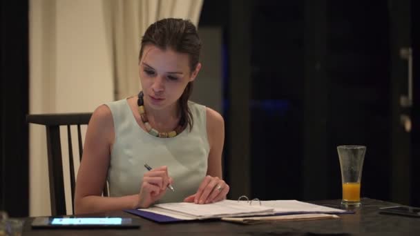 Femme d'affaires travaillant avec une tablette et écrivant dans des documents — Video