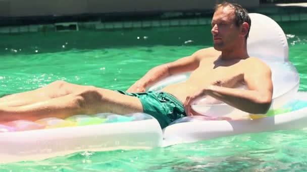 Man relaxing on air mattress in swimming pool — Stock Video