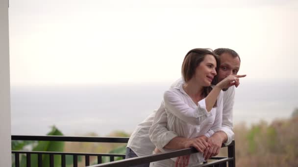 Paar steht auf Terrasse und schaut in die Natur — Stockvideo