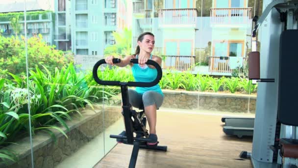 Kvinna utövar på maskin i gymmet — Stockvideo