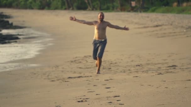 Mann rennt, dreht sich am Strand um — Stockvideo