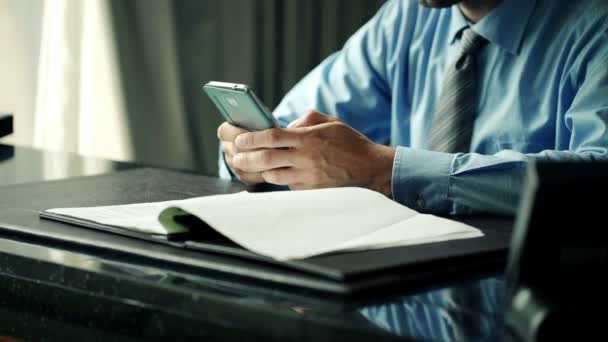 Empresário usando smartphone enquanto sentado à mesa — Vídeo de Stock