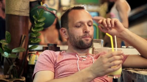 Nadenkend man drinken cocktail in café — Stockvideo