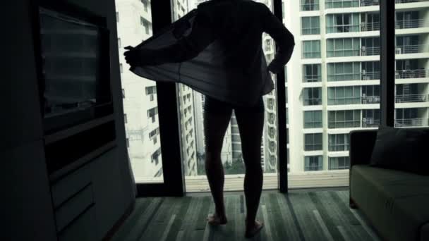 Man shirt opstijgen en uitzicht vanuit venster — Stockvideo