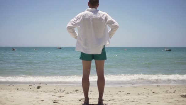 Άνθρωπος απολαμβάνοντας ηλιόλουστη μέρα στην παραλία — Αρχείο Βίντεο