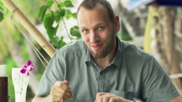 Hombre comiendo piña en exótica cafetería — Vídeos de Stock