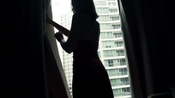 Femme dévoiler rideaux et admirer vue forme fenêtre — Video