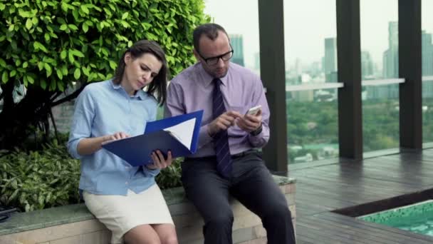 Ondernemers vergelijking van de gegevens op de documenten en smartphone — Stockvideo