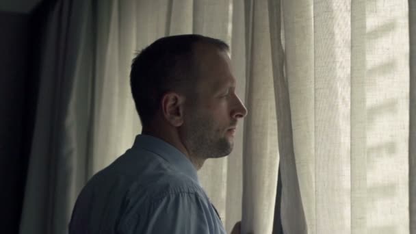Zakenman onthullen gordijnen en uitzicht vanuit venster — Stockvideo