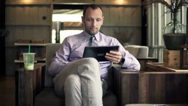 Бизнесмен работает один планшетный компьютер в кафе — стоковое видео