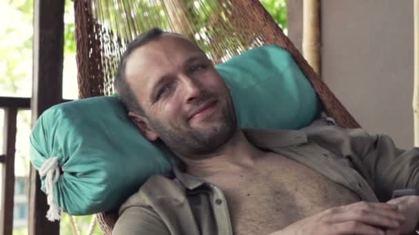 Homem feliz relaxando na rede — Vídeo de Stock