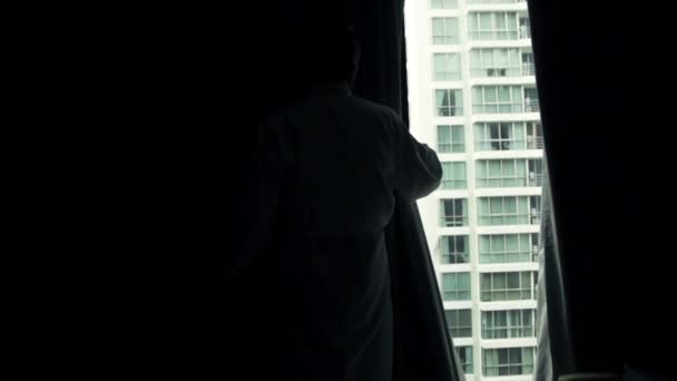 Man unveil curtains and admire view from window — Stock Video