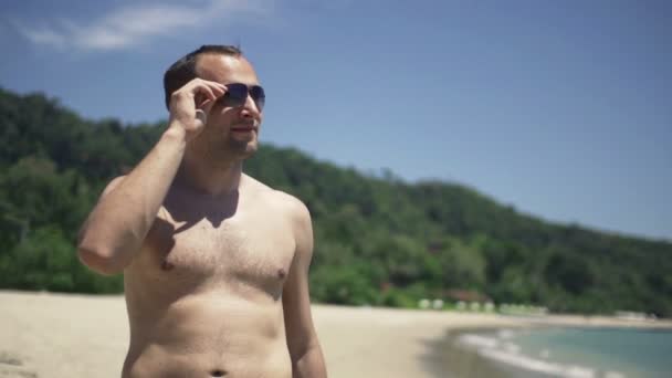 Jeune homme regardant autour sur la plage — Video