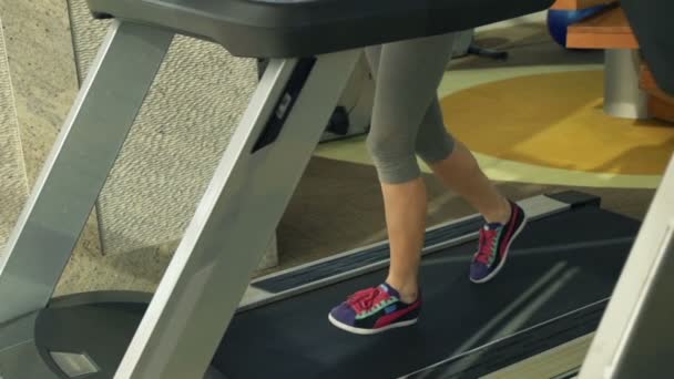 在健身房的跑步机上行走的女性双腿 — 图库视频影像