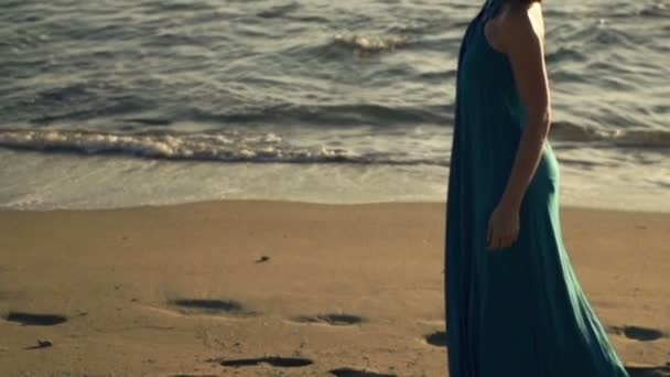 Mujer caminando en la playa al atardecer — Vídeos de Stock