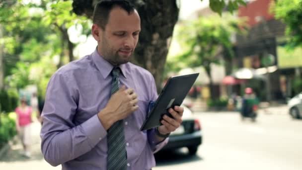 Businessman with tablet computer by street in city — Stock Video