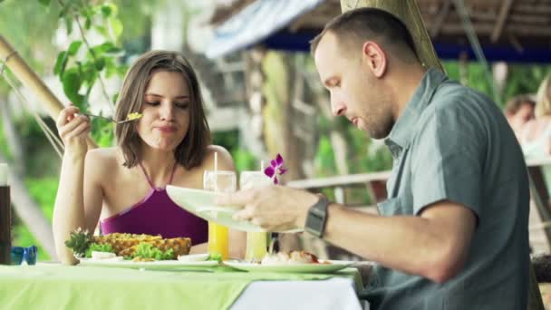 Pareja comiendo comida en exótica cafetería — Vídeos de Stock