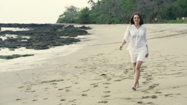 Jonge, gelukkige vrouw lopen op strand — Stockvideo