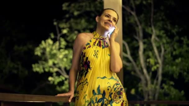 Mujer hablando por teléfono celular de pie en la terraza — Vídeos de Stock