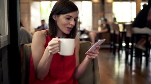 Femme avec smartphone boire du café dans le café — Video