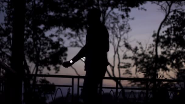 Man dansen terwijl u luistert naar muziek op het terras — Stockvideo