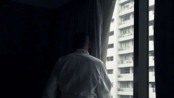 Homem desvendar cortinas e braços de alongamento — Vídeo de Stock